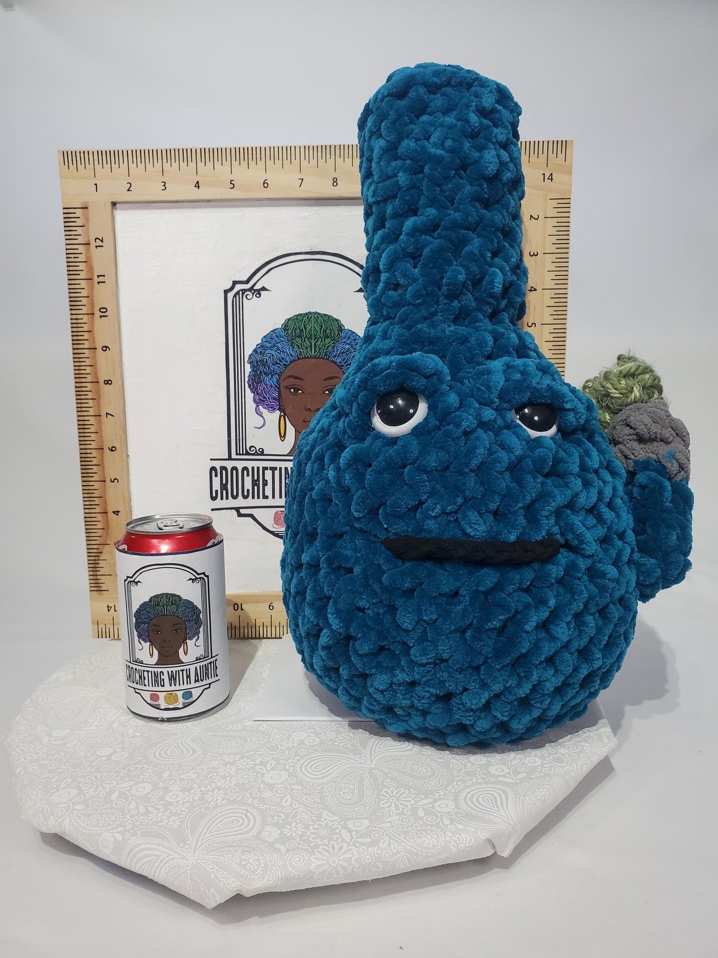 B18: Crochet Bong, Teal, made with 100% polyester soft blanket yarn and safety eyes, approx. 17" x 10", 1 lb 5 oz