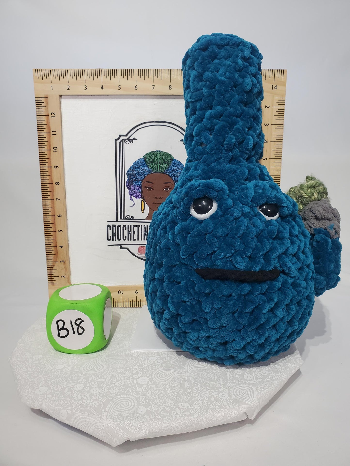 B18: Crochet Bong, Teal, made with 100% polyester soft blanket yarn and safety eyes, approx. 17" x 10", 1 lb 5 oz